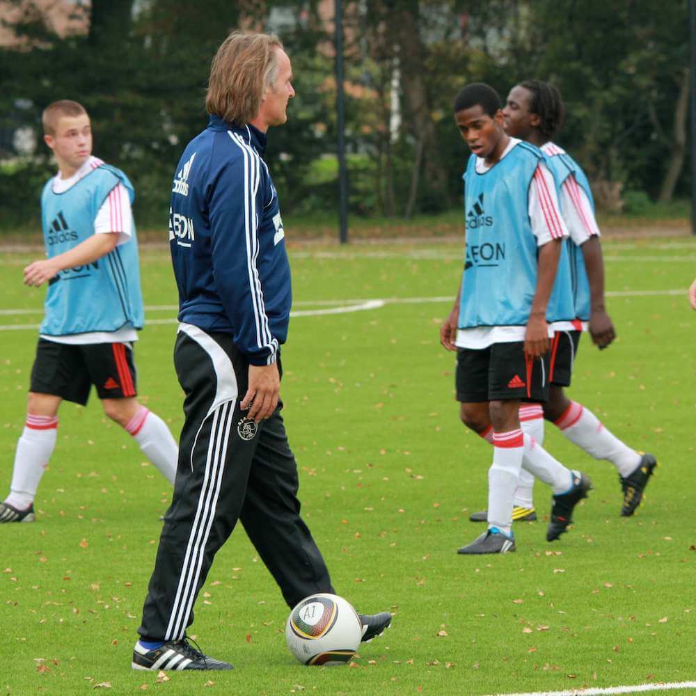 Coach_at_Ajax_training_session_watches_young_players