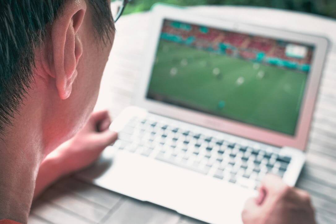 man-watches-football-footage-on-laptop-football4football